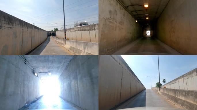 汽车通过旧混凝土隧道内的入口沿着道路和下坡行驶的前视图。