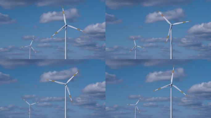 两台转动的风力发电机顶着白云的蓝天