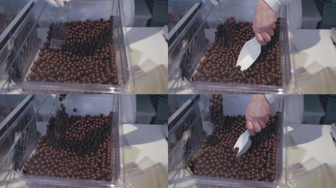 女人在生产厂包装干净包装的巧克力棕色球，慢动作