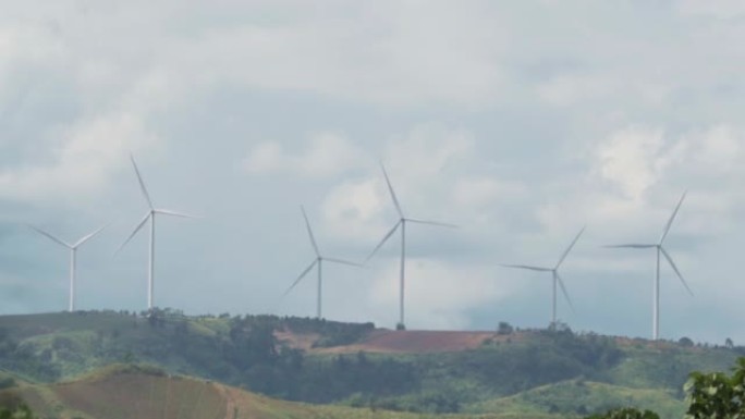 风力涡轮机在山上、白天的天空、可再生和清洁能源上发电。为未来减少碳排放的概念，从很远的距离拍摄，慢动