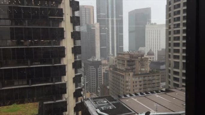 雨滴落在城市办公楼上层窗户上的视图