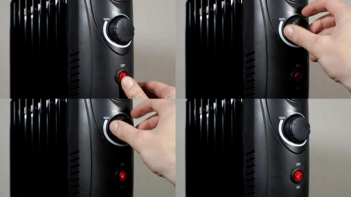 男人在家里按下电暖油电热散热器的电源按钮。“开” 或 “关” 调谐模式。家庭供暖和保温的概念。黑色充