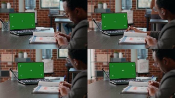 非裔美国人看着带绿屏的笔记本电脑