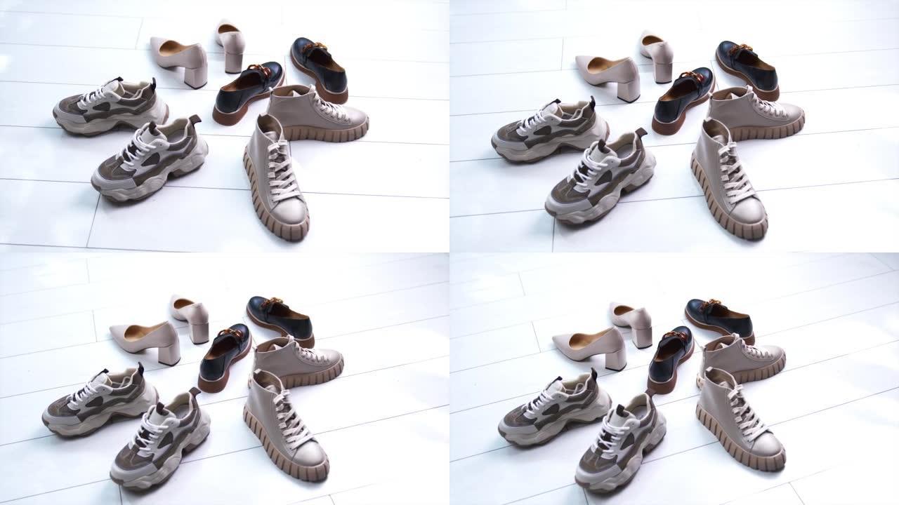 白色地板上围成一圈的各种鞋类。适合不同场合的现代时尚鞋子。特写。