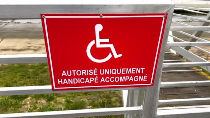 法国红色标志，指示在La Teste de Buch港口的浮桥上 “仅” 为陪同的残疾人保留的空间