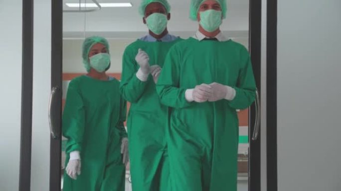 团队外科医生在统一的成功手术和步行中走出医院的手术室，团队合作的医生走出急诊室，具有多样性和种族，医