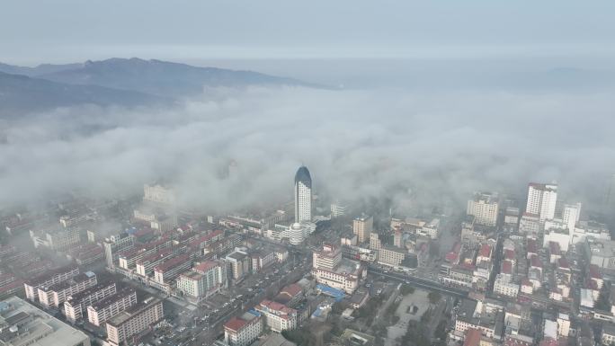 航拍环绕平流雾中的威海电力大厦