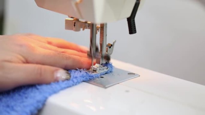 女性手缝在缝纫机上