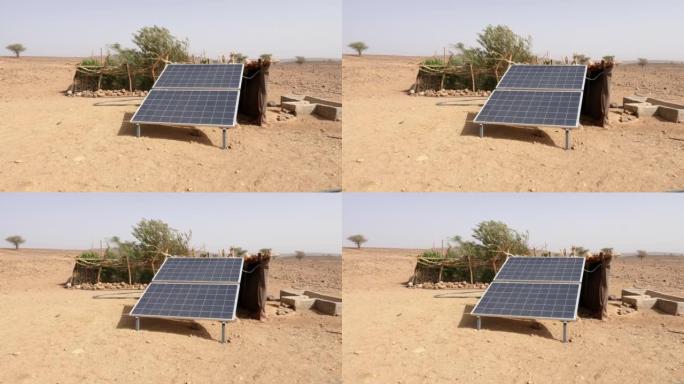 摩洛哥Erg Chigaga撒哈拉沙漠中的太阳能电池板。太阳能从水井为游牧民族的小菜园取水。