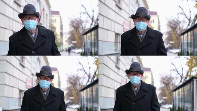 一位老人戴着防护口罩走在街上。社交距离上的人类生活。