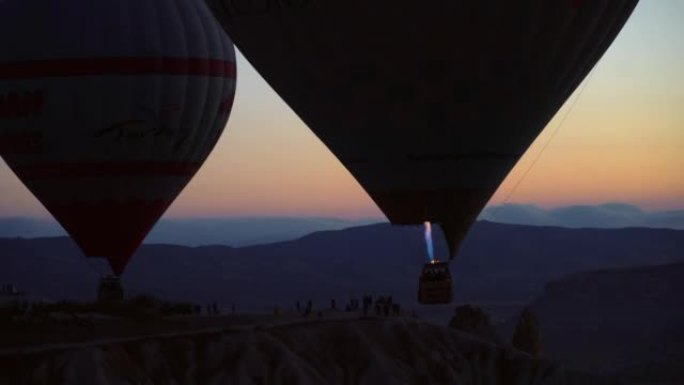 燃烧燃料的热气球与观光游客一起飞越Goreme市