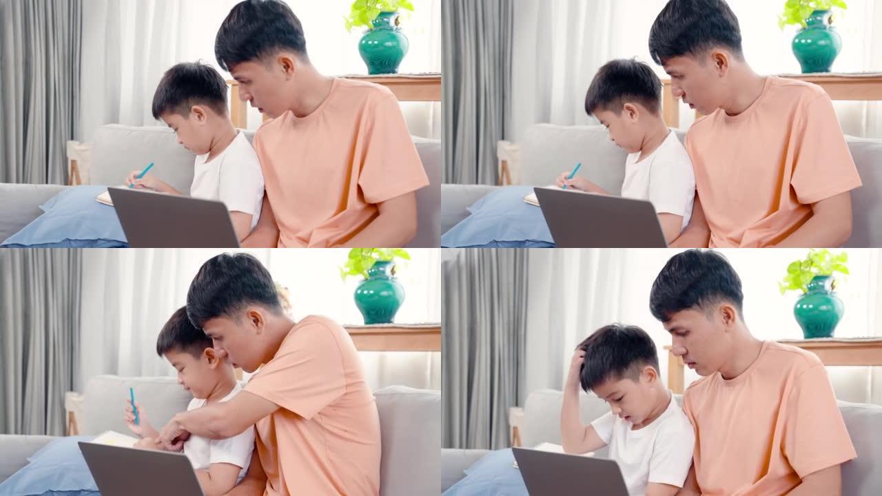 4K，亚洲单身父亲坐在笔记本电脑的工作中，不得不在家里客厅的沙发上心甘情愿地教儿子做作业。