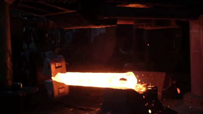 铁匠工厂。用工业锻压机锻造大型热金属坯。机器人工作的特写。金属锻造厂的技术设备。大型机器，铁匠移动并