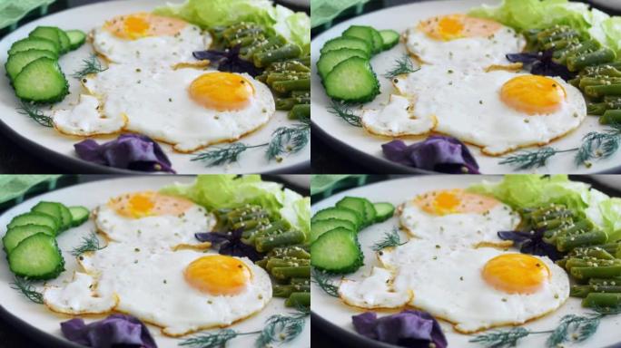 一对鸡蛋在有机植物油中煎炸，然后放在白色的盘子上，上面放有豆类，新鲜的黄瓜和绿叶。每天美味可口的早餐