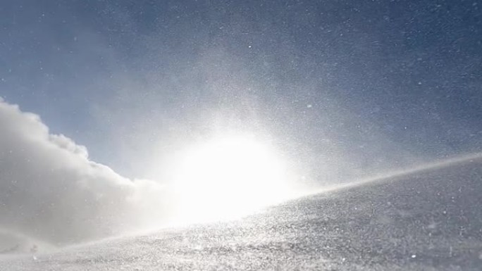 在寒冷的冬天早晨，暴风雪，暴风雪和积雪在山上漂流的特写镜头，阳光照耀着。慢动作