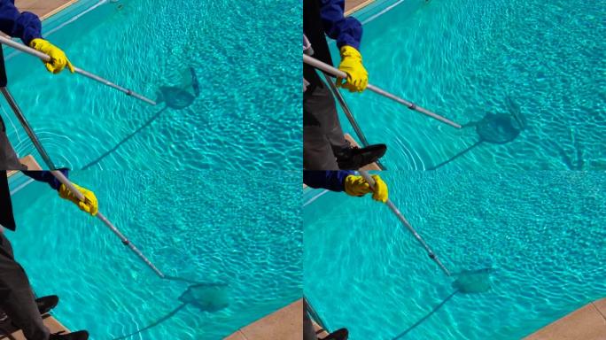 用特殊的网眼清理水池中的碎屑。游泳池的维护，蓝色的清水。复制空间。选择性聚焦。肮脏的水池，底部有细小