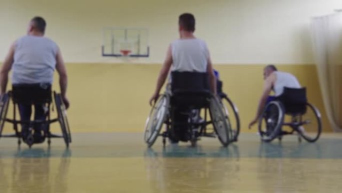 在学校体育馆里，坐在轮椅上玩篮球队比赛的残障运动者的特写镜头。选择性聚焦。