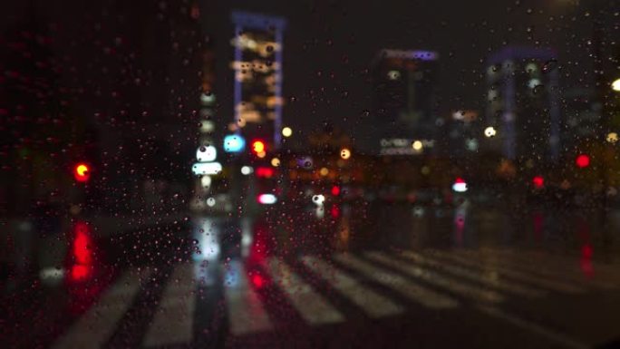 夜间市区下雨天交通散焦，车灯