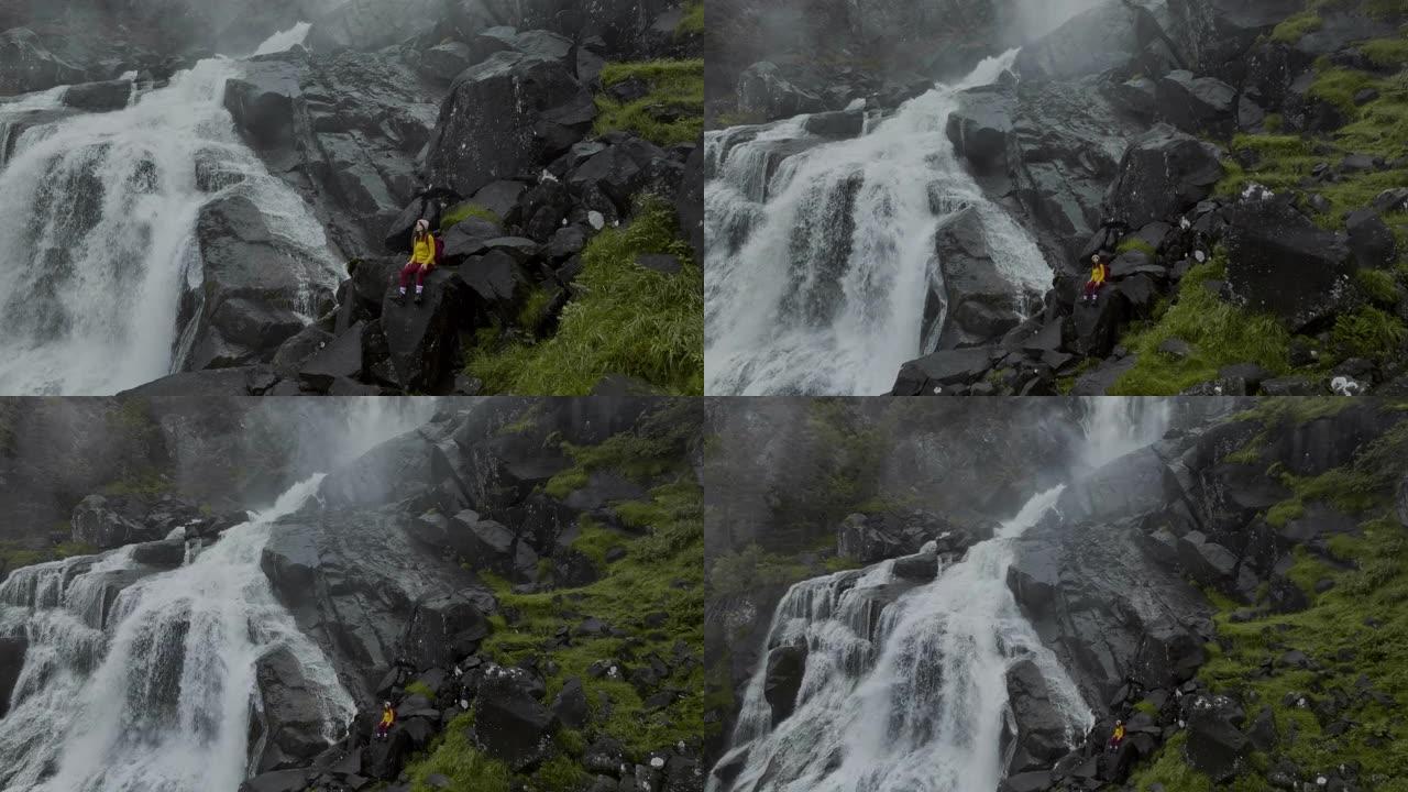 挪威山区瀑布附近徒步旅行的妇女的鸟瞰图