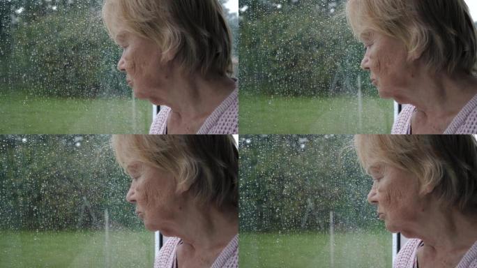 悲伤的老年女性希望在雨中走出窗外