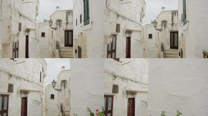 欧洲老城区狭窄的小街白色房屋，没有路灯悬挂墙壁