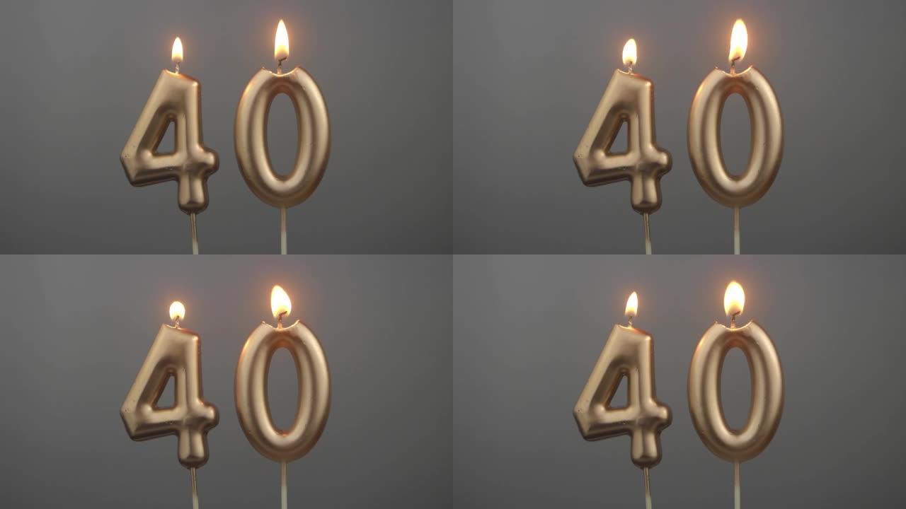 灰色背景上燃烧的金色生日蜡烛，40号
