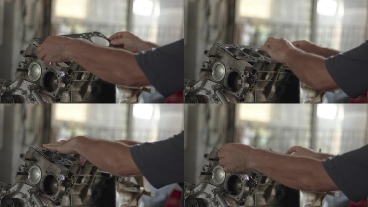 汽车大师在修理厂的工作台上安装垫片并修理有故障的汽车发动机