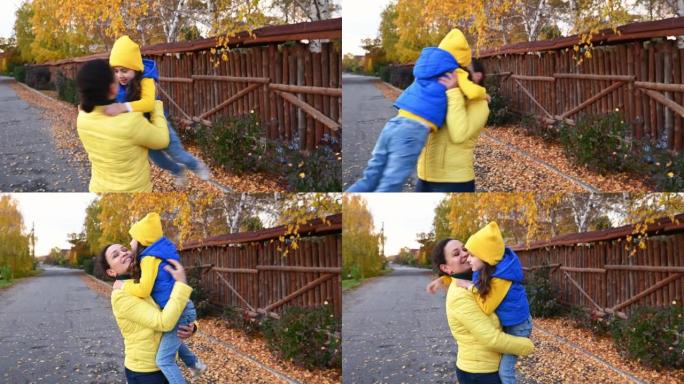 幸福的家庭关系。关爱母亲。慈爱的妈妈在秋天公园散步时拥抱和盘旋女儿