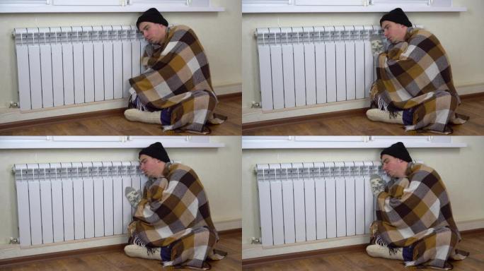 一个戴着帽子，穿着格子衣服的男人对着地板上的暖气片。一个年轻人因为没有付取暖费而冻在家里。4 k