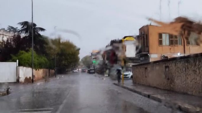 意大利罗马，10月-10。2022。在雨中行驶时，通过车窗行驶的道路视图。在雨中从汽车挡风玻璃上的交