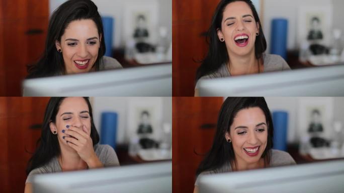 西班牙裔女孩在办公室电脑屏幕前大笑