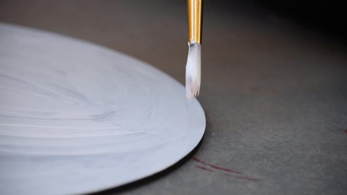 艺术家用刷子在木板上画白色的特写镜头。创造力和艺术爱好的概念。