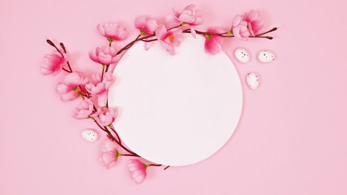 在柔和的粉红色背景上复制带有春天花朵装饰的太空圈。停止运动。平铺