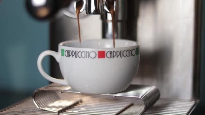 咖啡机将浓缩咖啡倒入卡布奇诺杯子的特写视图