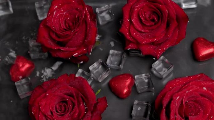 水中的红玫瑰，心在冰片之间。水滴落下。黑色背景。情人节