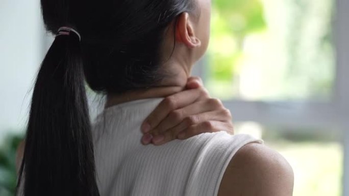 亚洲女人肩膀疼痛。女性用另一只手握住痛苦的肩膀。身体肌肉有问题、医疗保健和医学的人。