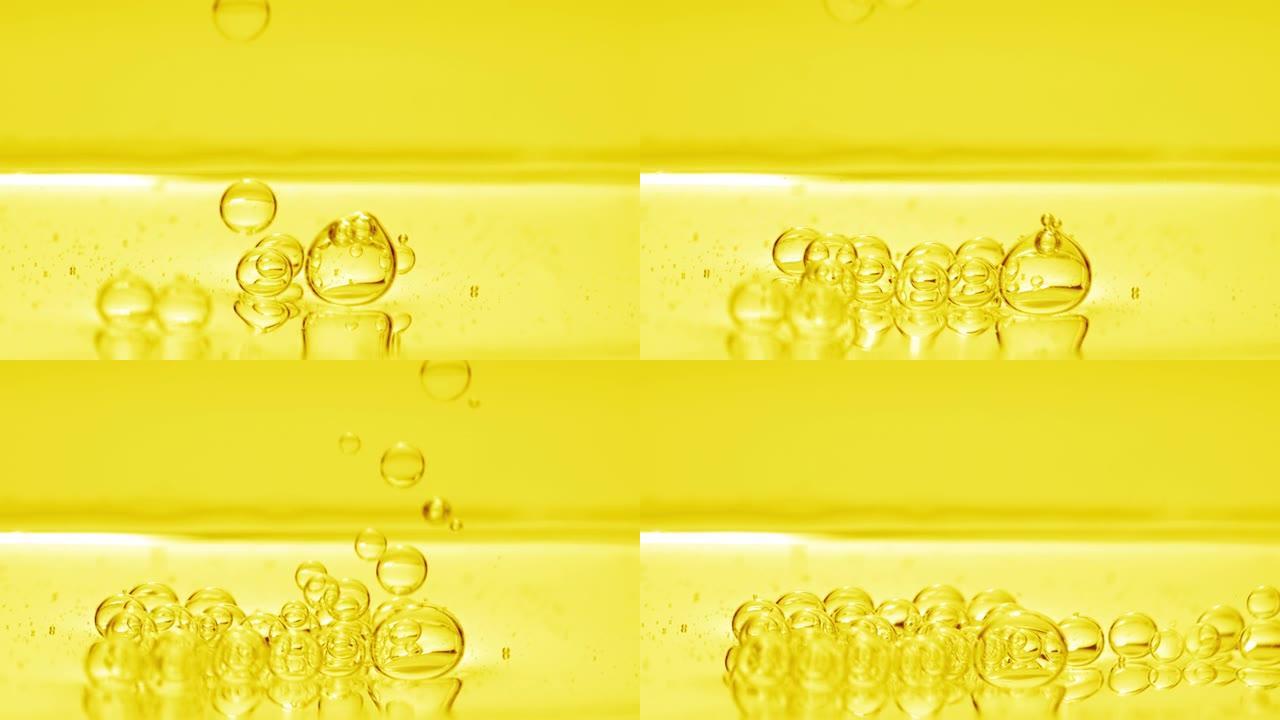 黄色气泡沉入黄色背景下的液体表面