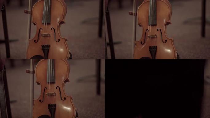 大提琴在地面上的特写镜头，弓在模糊的背景下