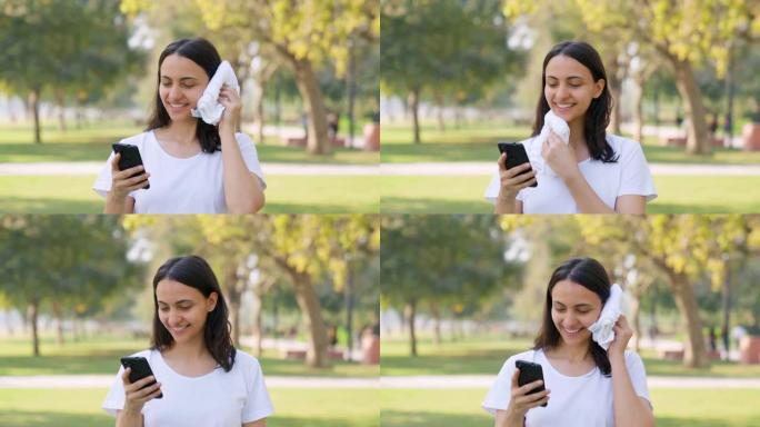 印度妇女一边擦汗一边滚动手机