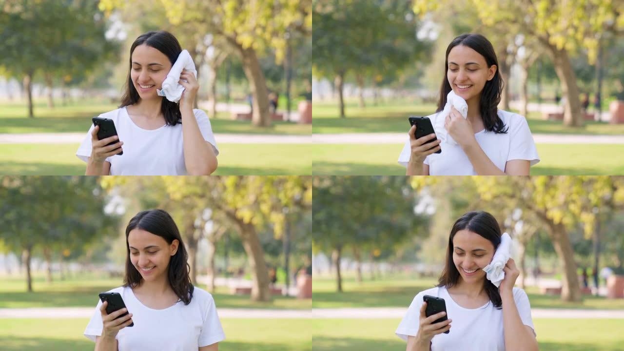 印度妇女一边擦汗一边滚动手机