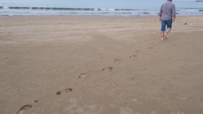 脚印，男人走在沙滩上的脚印可以看到