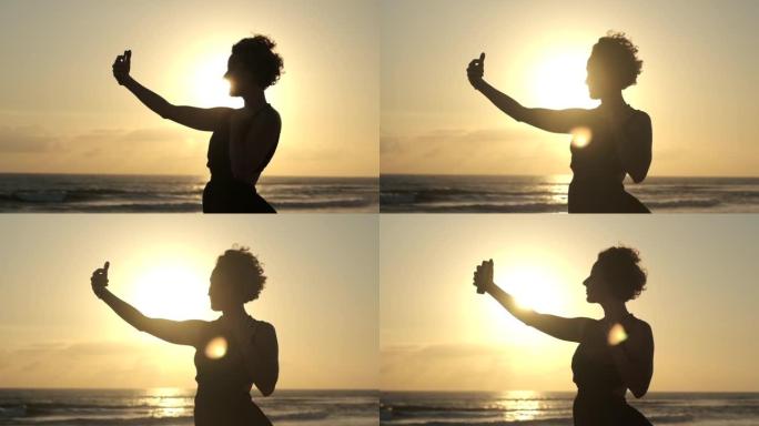 白人妇女站在地平线上落日的最后一道明亮的光线中，摆姿势对着镜头，想为她的博客拍摄美丽的照片。
