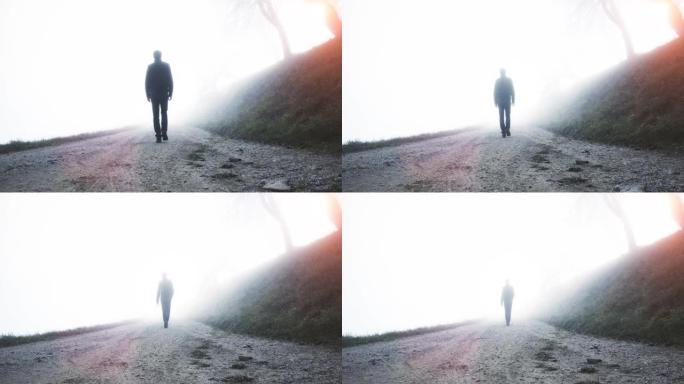 一个人独自走在乡村迷雾之路上。
