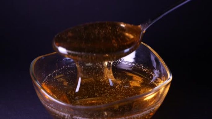 黑色背景上拍摄的液体蜂蜜