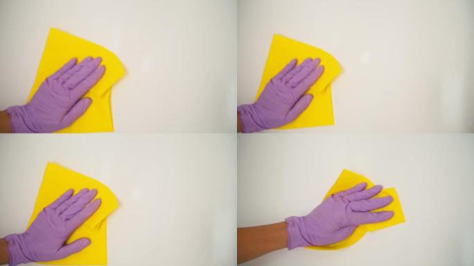 用乳胶手套清洁白色表面的手的特写镜头