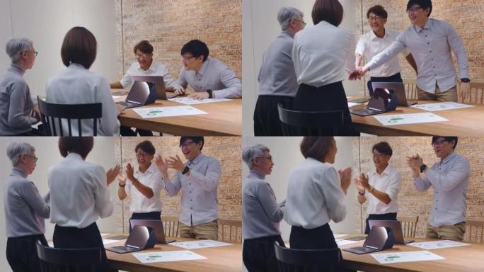 一群亚洲创意商业人士叠手将手掌放在一起。员工团队人员在办公室会议室形成手堆。团结不同、信任和团队建设