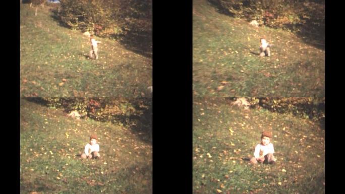 70年代的8毫米镜头-20世纪70年代的小男孩在草地上奔跑，掉在草地上