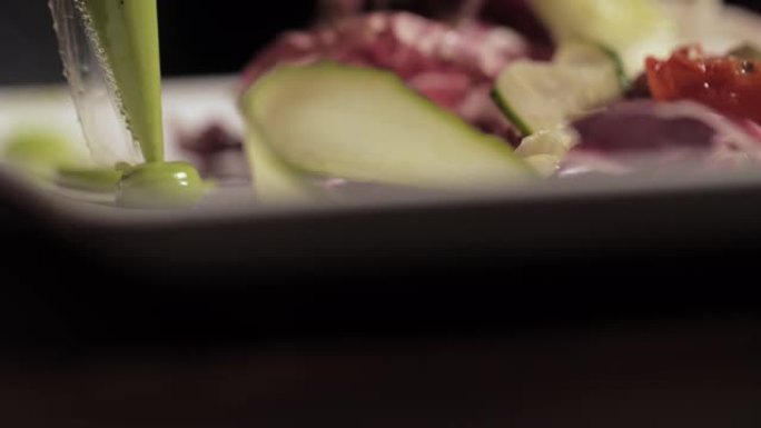 厨师在沙拉中加入美味的绿色酱汁，配以新鲜的蔬菜和海鲜。