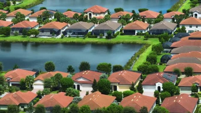 从佛罗里达州南部封闭的生活俱乐部的保留池塘附近密集建造的住宅的上方观看。美国梦homes作为美国郊区