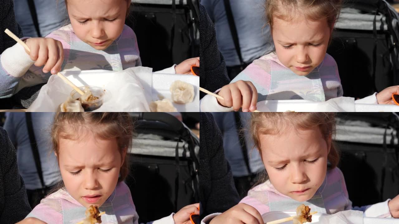 儿童小女孩肖像用筷子吃酱油肉饺子